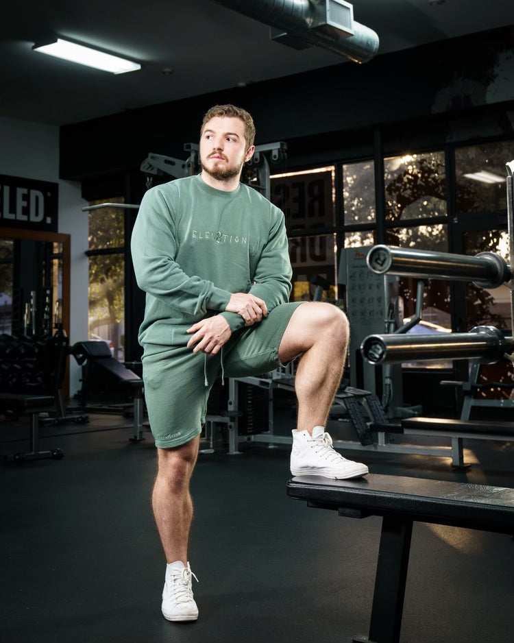 green shorts and crewneck with Elev8tion on the chest