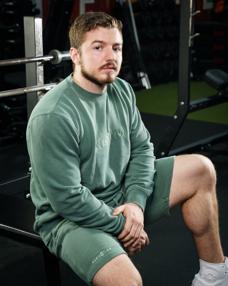 green shorts and crewneck with Elev8tion on the chest