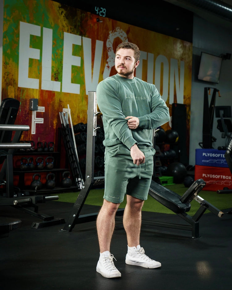 green shorts and crewneck with Elev8tion on the chest